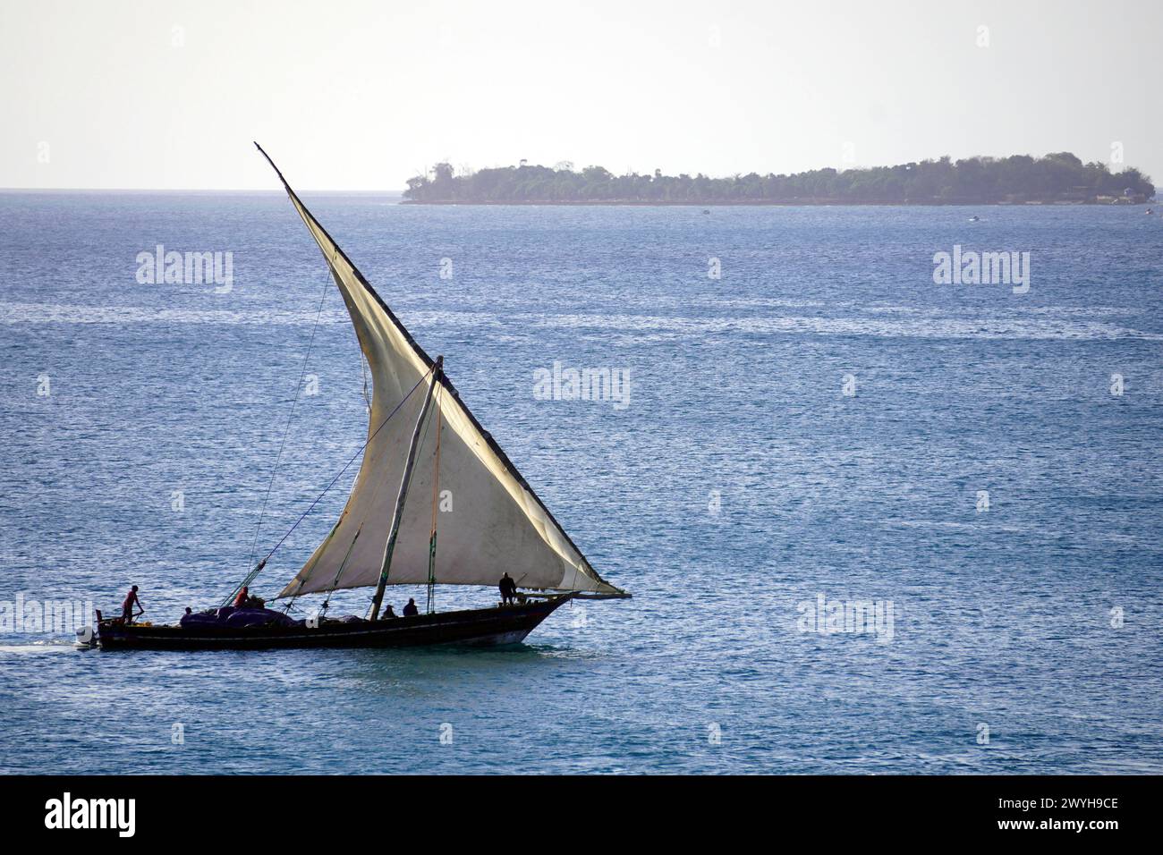 Dhow naviguant sur une mer calme avec une île au loin Banque D'Images