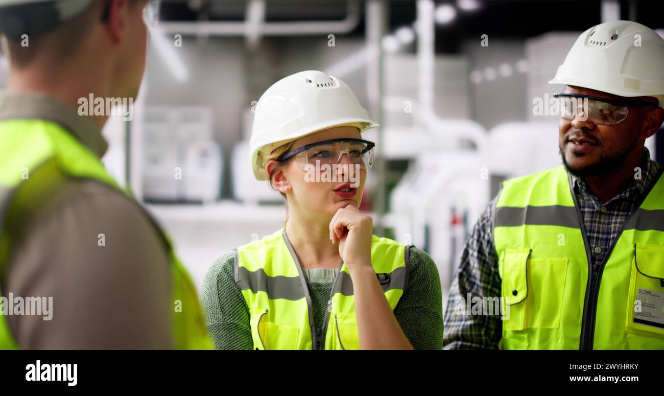 L'équipe d'ingénieurs d'usine parle à l'usine de fabrication industrielle Banque D'Images L'équipe d'ingénieurs d'usine parle à l'usine de fabrication industrielle Banque D'Images