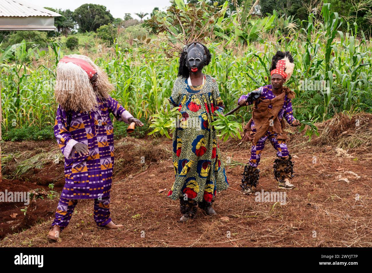 Cameroun, secteur ouest, quartier de Ndé, Bagangté, cérémonie funéraire, 2 hommes portant des vêtements traditionnels et un homme déguisé en femme avec masque Banque D'Images