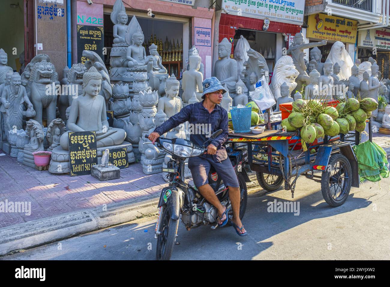 Cambodge, Phnom Penh, quartier de Doun Penh, vendeur de rue de noix de coco devant les magasins de tailleurs de pierre Banque D'Images