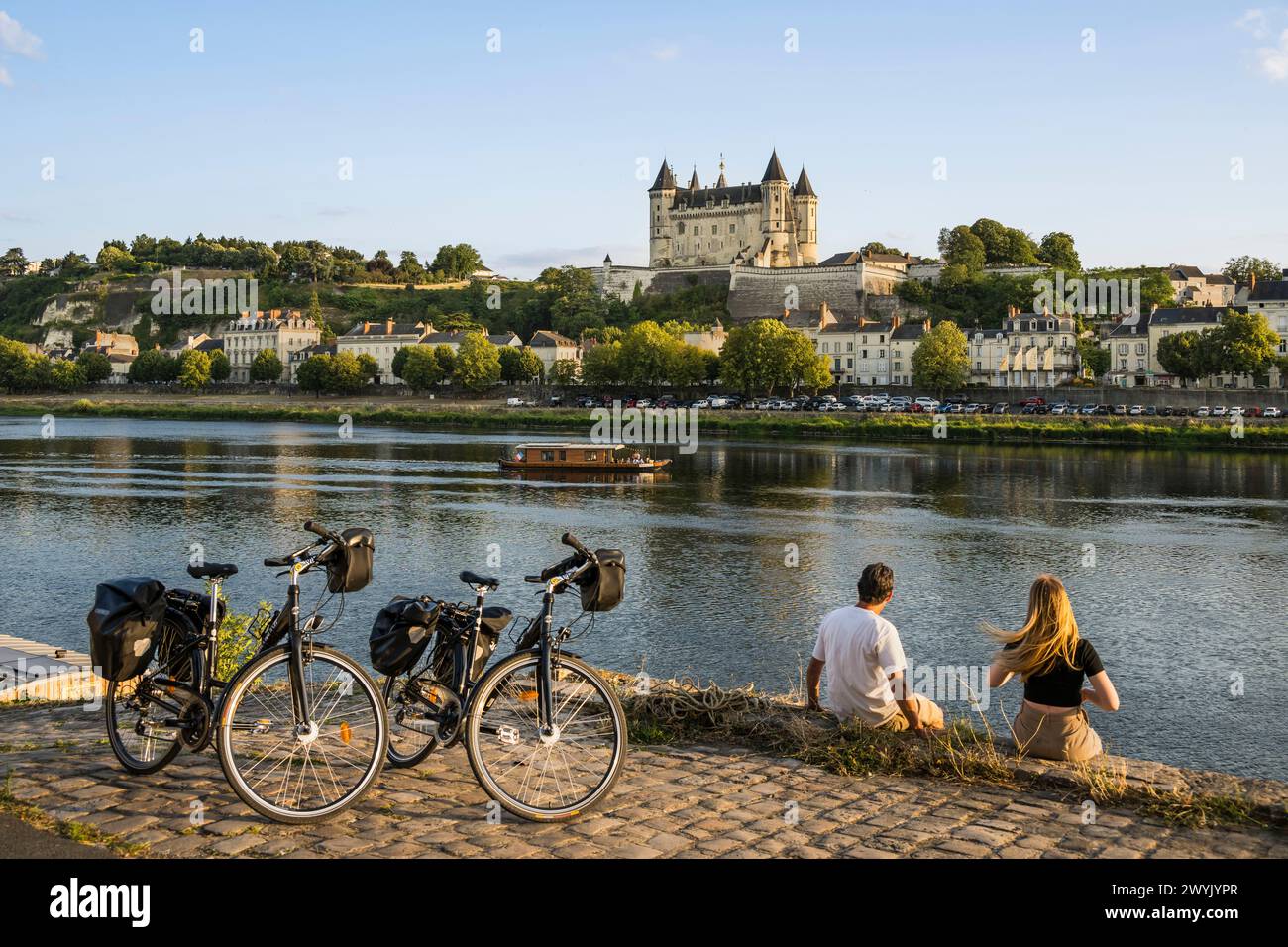 France, Maine-et-Loire, vallée de la Loire classée au Patrimoine mondial de l'UNESCO, Saumur, vélo sur les bords de Loire, le château et l'église Saint-Pierre sur les bords de Loire Banque D'Images