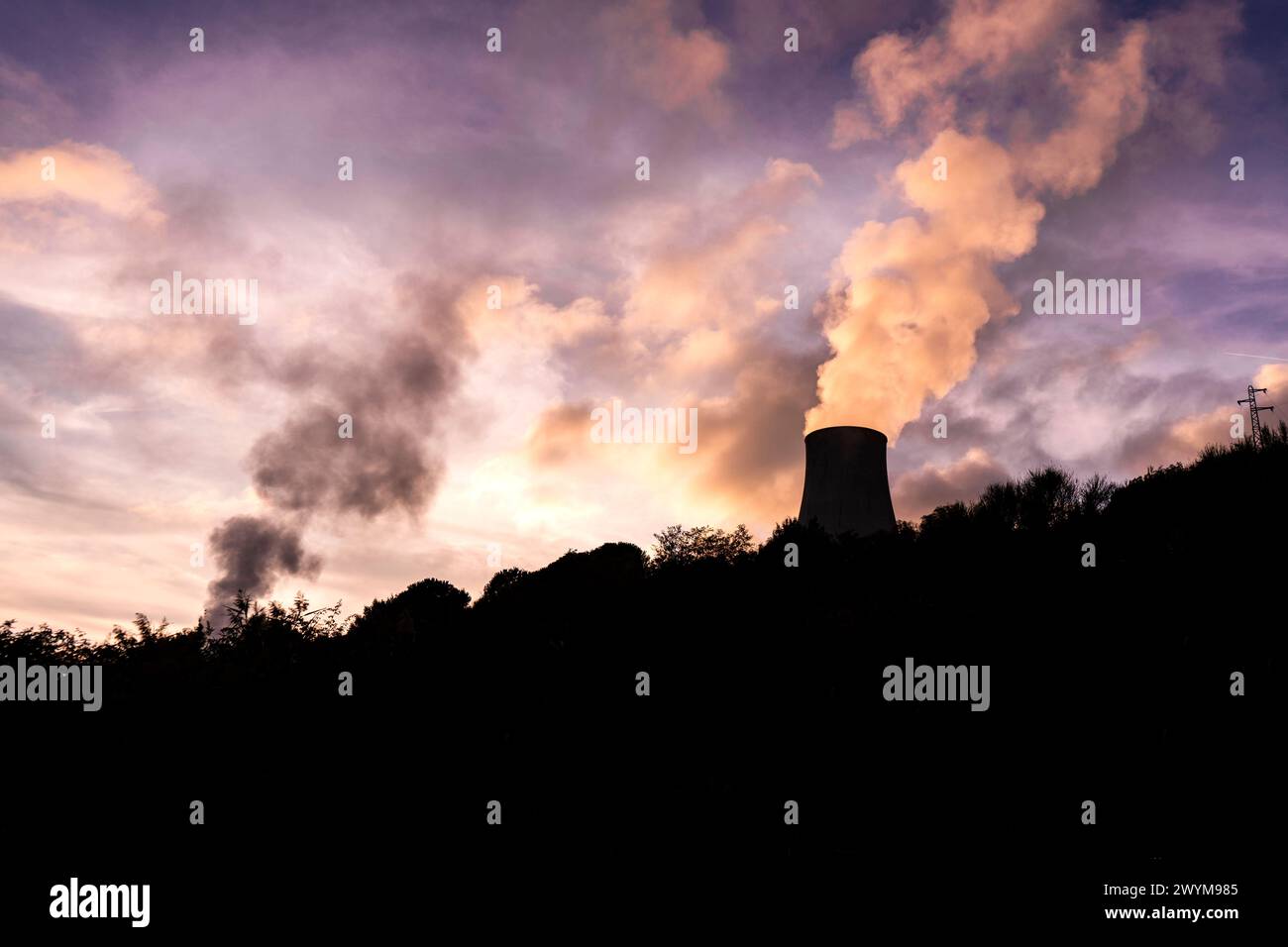 Silhouette de tour de refroidissement d'une centrale géothermique au coucher du soleil, avec un ciel rose-violet à Monterotondo Marittimo, près de Larderello, en Toscane, Italie Banque D'Images