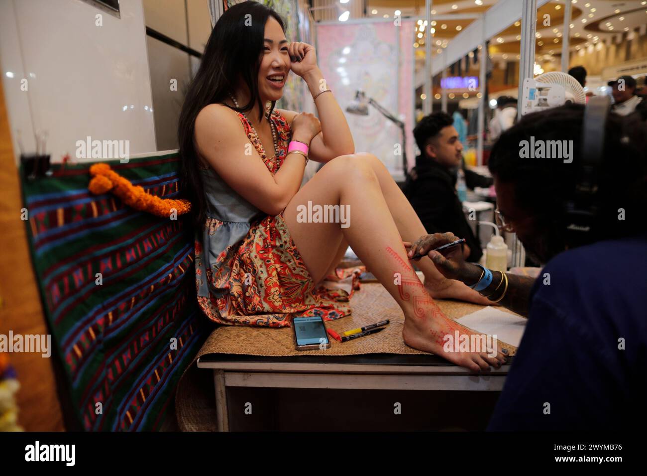 Lalitpur, Népal. 05th Apr, 2024. Une femme sourit alors qu'elle se fait encrer sur sa jambe par un tatoueur pendant la Convention internationale de tatouage. International Tattoo Convention, est la plus grande convention de tatouage au Népal avec plus de 90 cabines de tatouage et 200 tatoueurs du monde entier à Heritage Garden à Lalitpur. (Photo de Skanda Gautam/SOPA images/SIPA USA) crédit : SIPA USA/Alamy Live News Banque D'Images