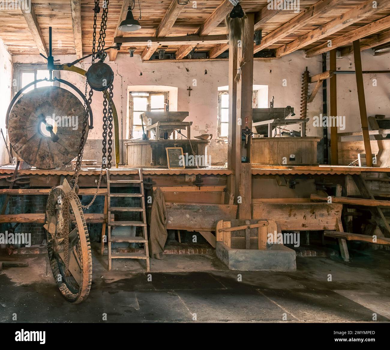 Intérieur de l'ancien moulin à eau italien de la vallée du Pô dans la province de Cuneo, Italie. Structure de moulin en bois avec grande meule Banque D'Images
