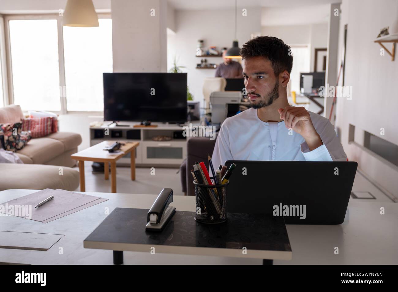 Les hommes arabes sont en plein travail au bureau en s'aidant les uns les autres Banque D'Images