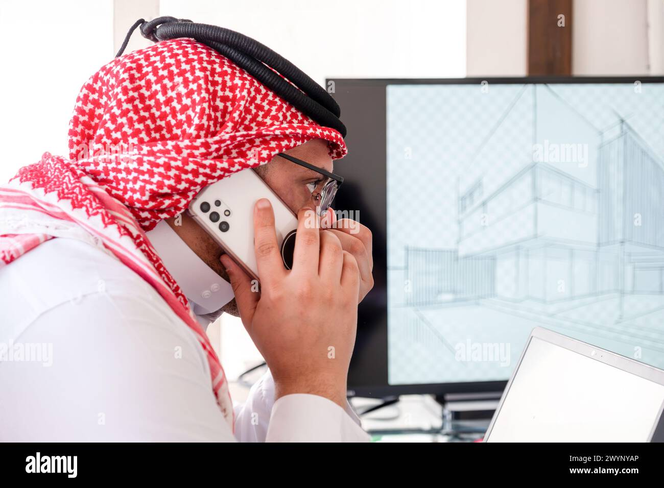 homme arabe utilisant le téléphone pendant le travail pour s'assurer qu'il est flux est dans la bonne direction Banque D'Images