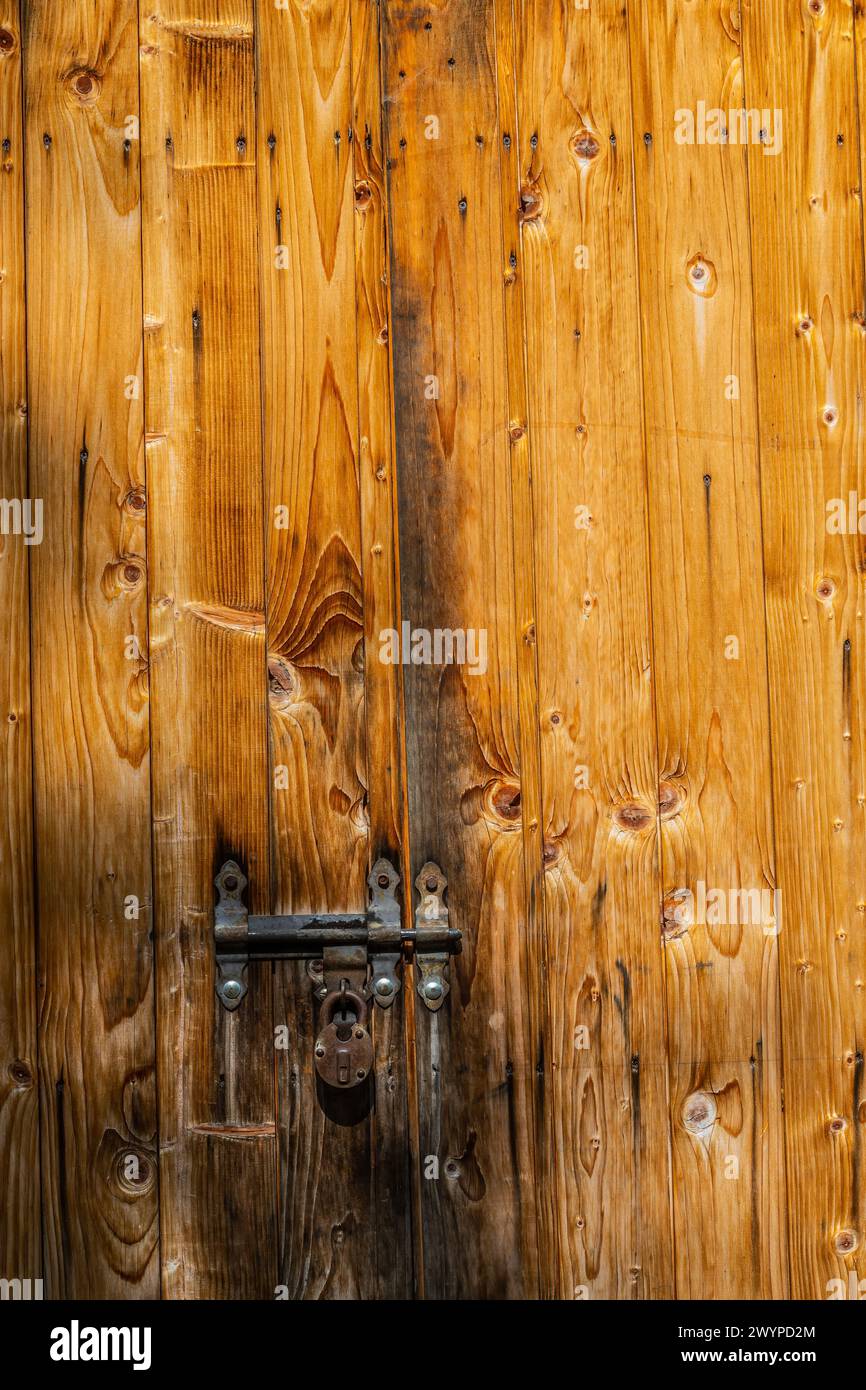 Vue rapprochée de l'ancien cadenas rouillé sur une porte en bois gris vieilli. Banque D'Images