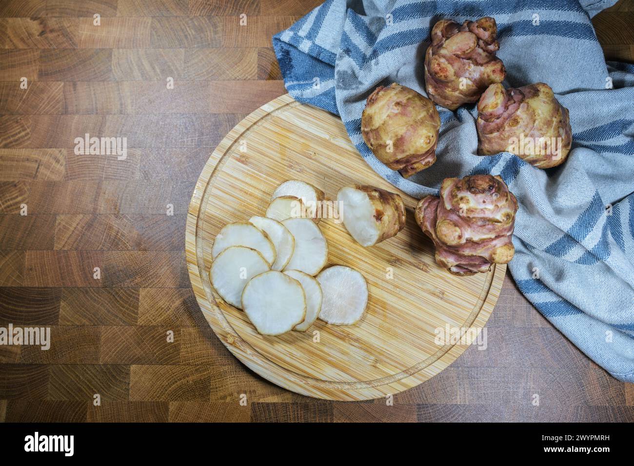 Artichaut de Jérusalem ou topinambur (Helianthus tuberosus), sur une planche de cuisine en bois, légume-racine sain, riche en inuline pour l'amincissement et le diabète Banque D'Images