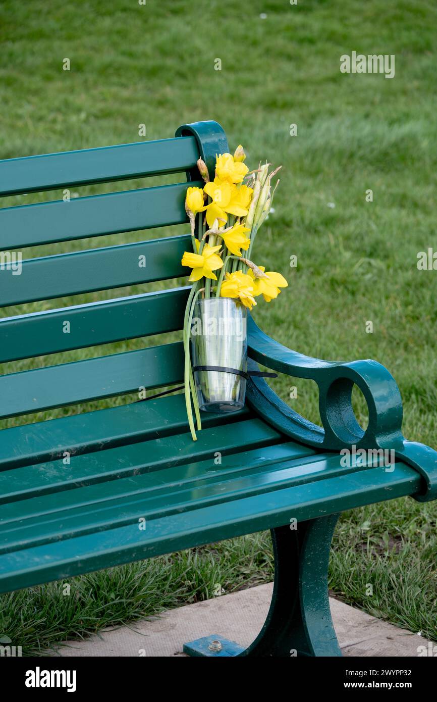 Fleurs commémoratives sur un banc à Hillfield Park, Monkspath, Solihull, West Midlands, Angleterre, ROYAUME-UNI Banque D'Images