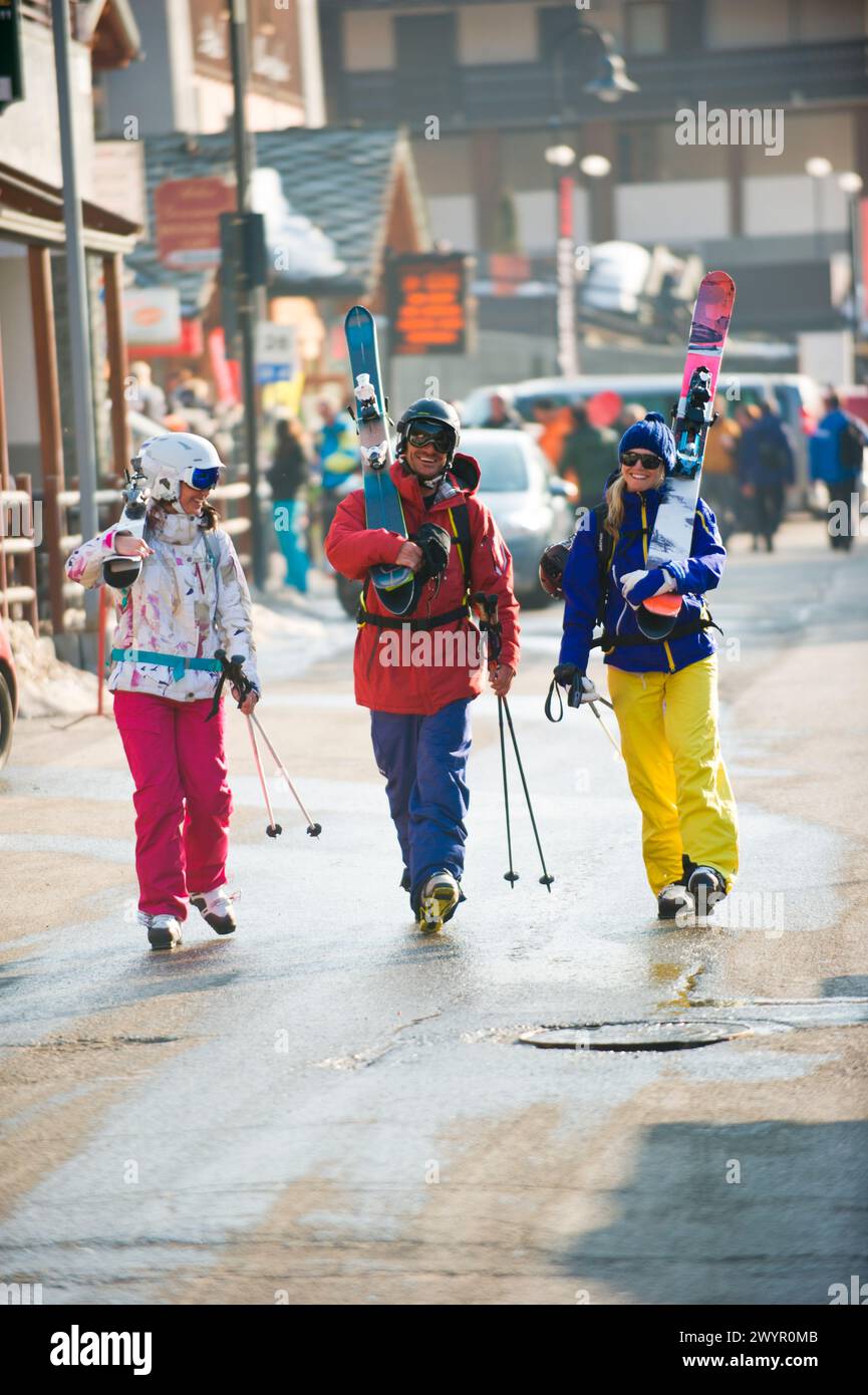 Trois skieurs marchant dans la rue dans le village italien Champoluc en Italie. Banque D'Images