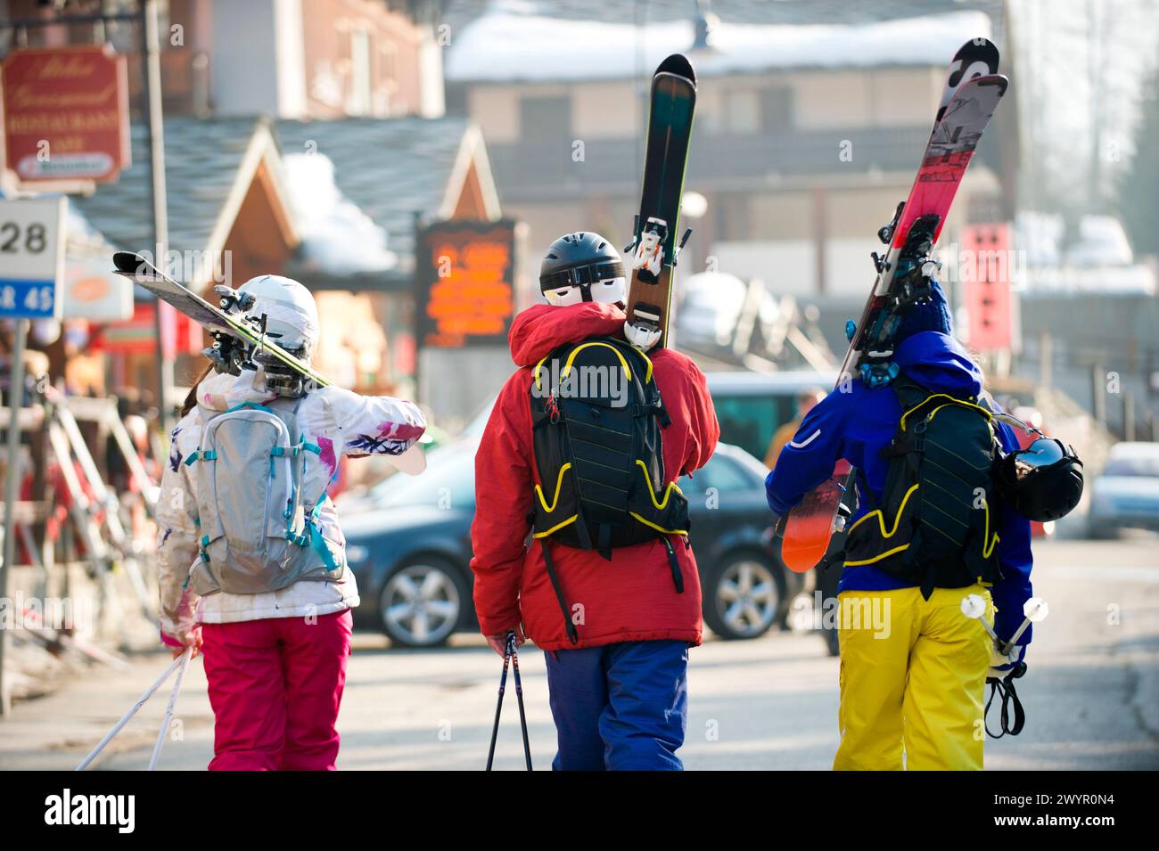 Trois skieurs marchant dans la rue dans le village italien Champoluc en Italie. Banque D'Images