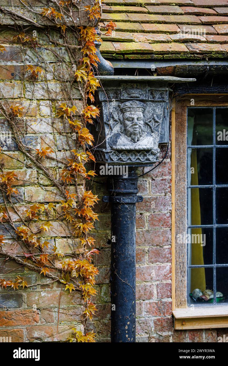 Une trémie en métal vintage avec le portrait d'un roi couronné dans le système de gouttières de Vann House près de Hambledon, Surrey au début du printemps Banque D'Images