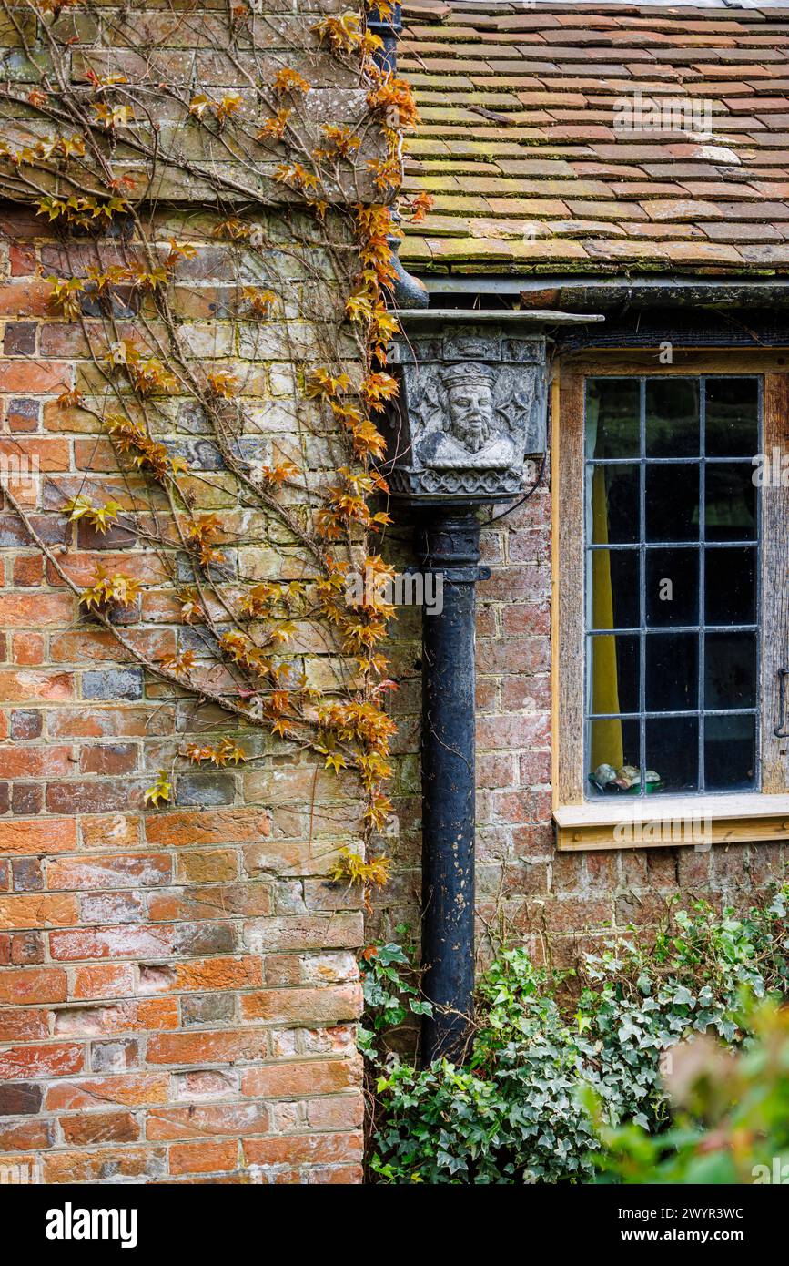 Une trémie en métal vintage avec le portrait d'un roi couronné dans le système de gouttières de Vann House près de Hambledon, Surrey au début du printemps Banque D'Images