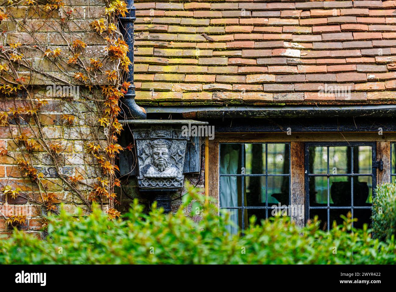 Une trémie en métal vintage avec le portrait d'un roi couronné dans le système de gouttières de Vann House près de Hambledon, Surrey au début du printemps Banque D'Images