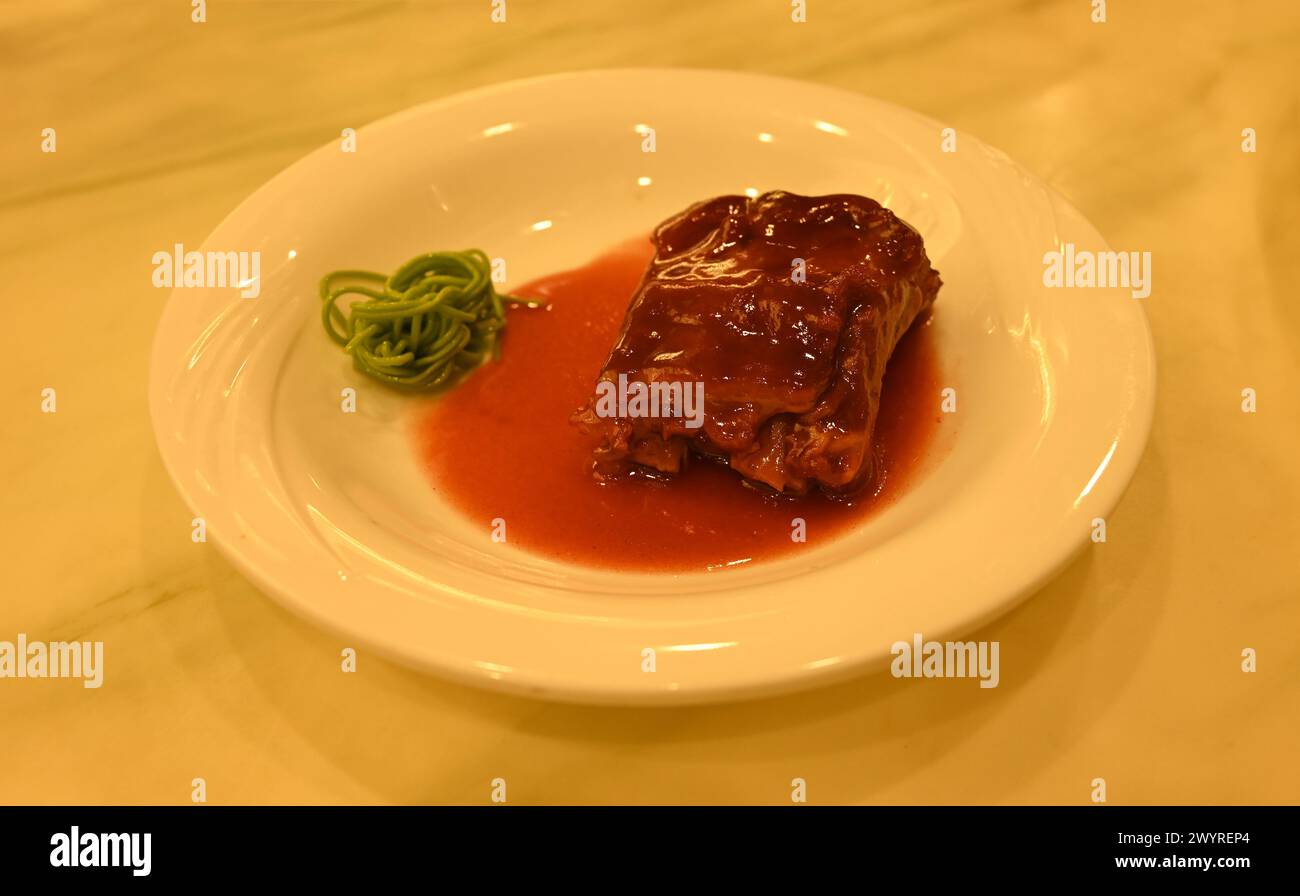 steak de porc braisé frais avec nouilles vertes dans une assiette blanche pour manger Banque D'Images