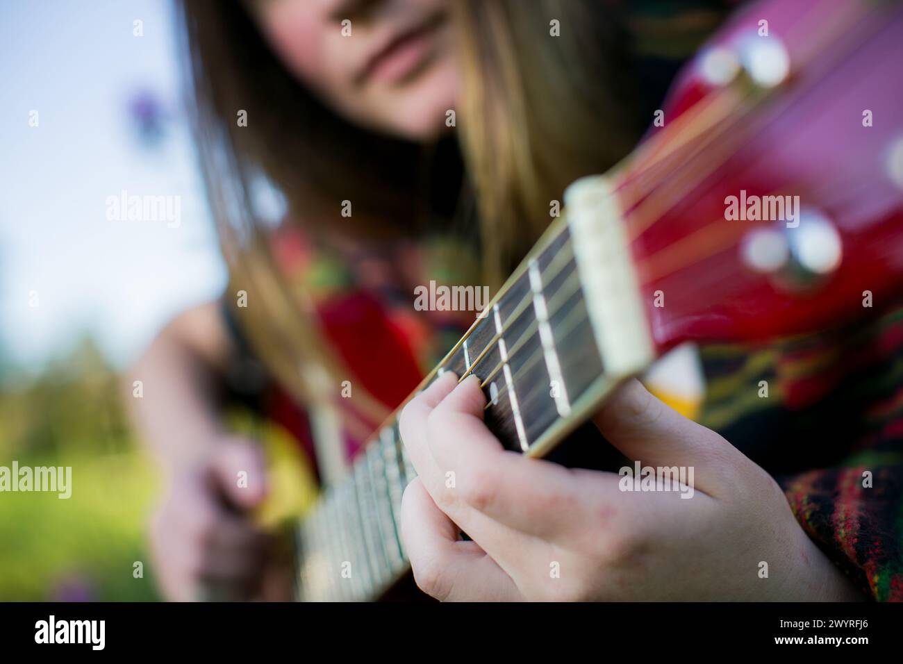 Gros plan des mains d'une fille jouant de la guitare. Banque D'Images