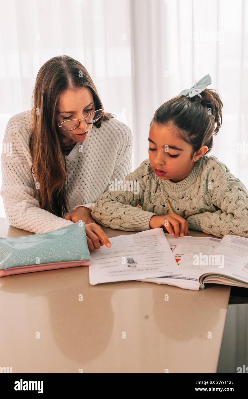 Maman aidant sa fille avec ses devoirs scolaires Banque D'Images