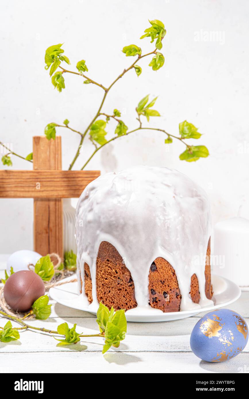 Fond de vacances chrétiennes orthodoxes catholiques de Pâques, avec symbole de croix en bois de la religion, cuisson du gâteau de Pâques avec glaçage au sucre, oeuf peint coloré Banque D'Images