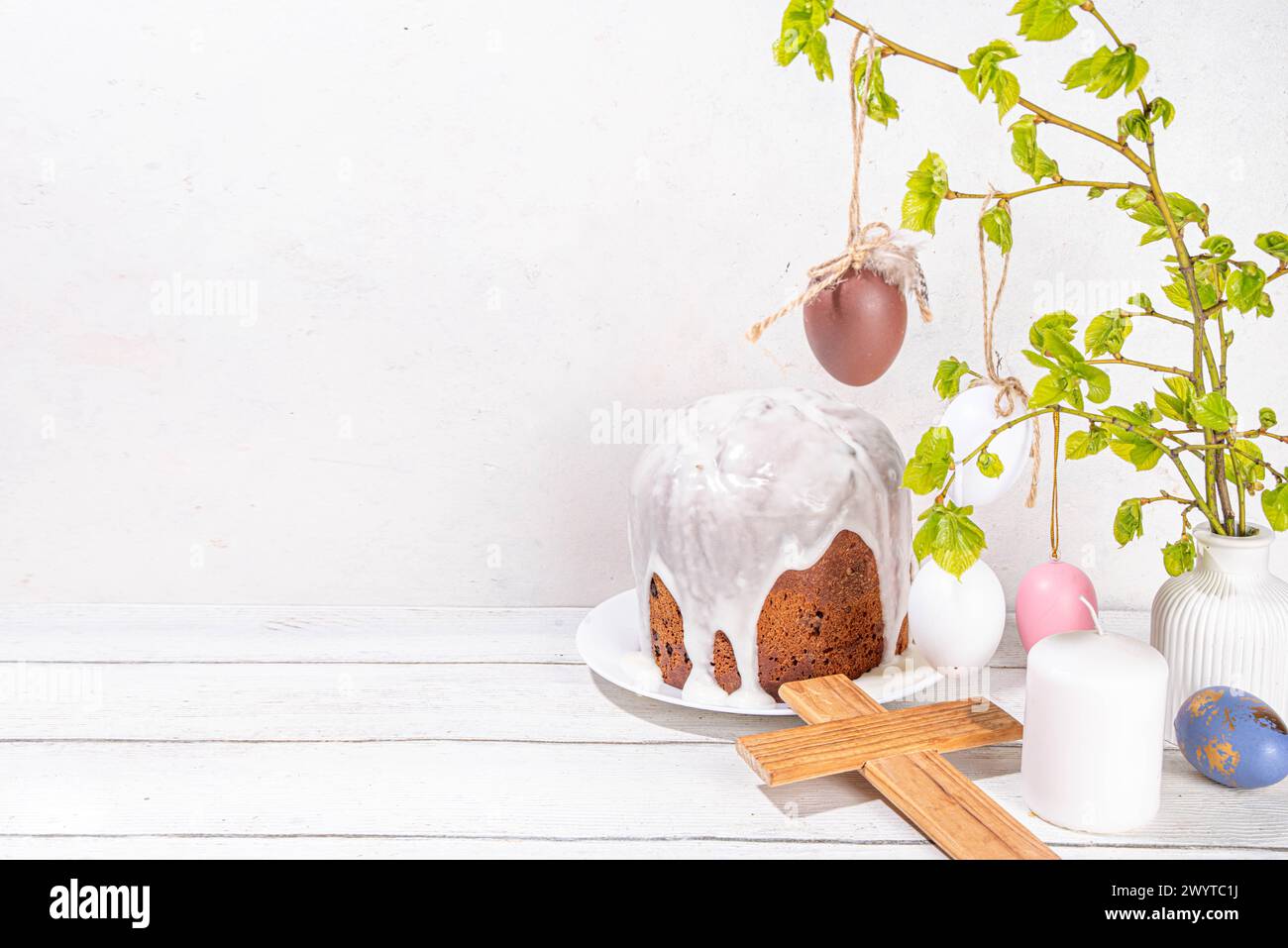 Fond de vacances chrétiennes orthodoxes catholiques de Pâques, avec symbole de croix en bois de la religion, cuisson du gâteau de Pâques avec glaçage au sucre, oeuf peint coloré Banque D'Images