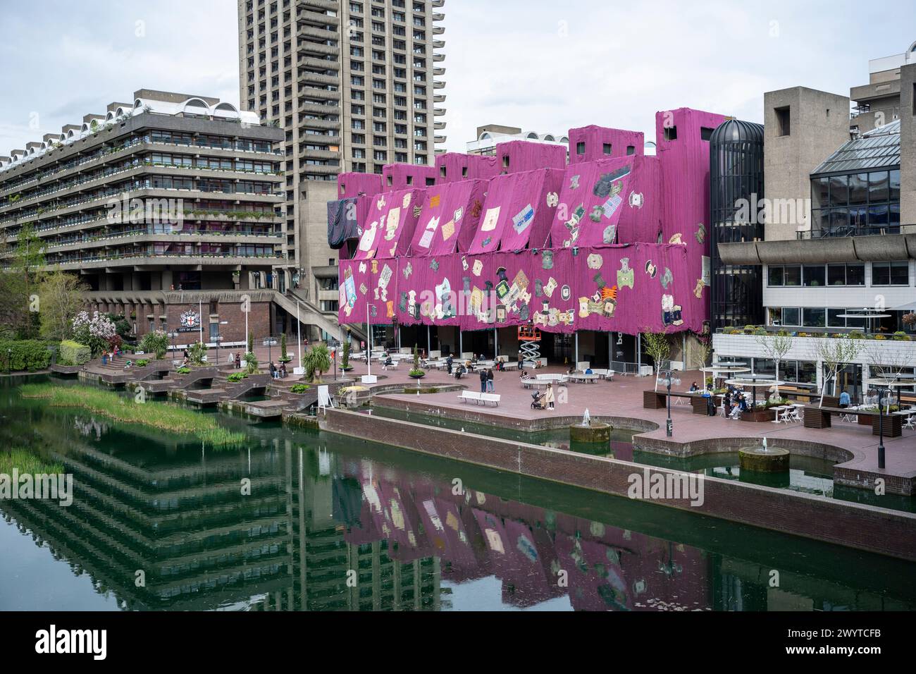 Londres, Royaume-Uni. 8 avril 2024. «Violet Hibiscus», 2023-24, de l'artiste ghanéen Ibrahim Mahama est installé à l'extérieur de la Barbican. L’installation spécifique au site a été commandée par le responsable des arts visuels de Barbican, Shanay Jhaveri, et comprend 2000 m² de tissu tissé rose et violet fait à la main pesant 20 tonnes. Une inspection plus approfondie montre 100 robes traditionnelles, appelées batakaris, portées par les rois ghanéens. L’œuvre coïncide avec l’exposition en cours du Barbican « Unravel : The Power and Politics of textiles in Art ». Credit : Stephen Chung / Alamy Live News Banque D'Images Londres, Royaume-Uni. 8 avril 2024. «Violet Hibiscus», 2023-24, de l'artiste ghanéen Ibrahim Mahama est installé à l'extérieur de la Barbican. L’installation spécifique au site a été commandée par le responsable des arts visuels de Barbican, Shanay Jhaveri, et comprend 2000 m² de tissu tissé rose et violet fait à la main pesant 20 tonnes. Une inspection plus approfondie montre 100 robes traditionnelles, appelées batakaris, portées par les rois ghanéens. L’œuvre coïncide avec l’exposition en cours du Barbican « Unravel : The Power and Politics of textiles in Art ». Credit : Stephen Chung / Alamy Live News Banque D'Images