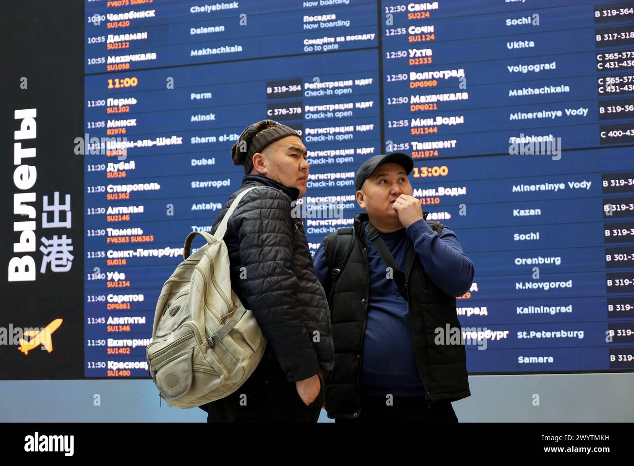 Passagers regardant le tableau de départ dans le terminal B de l'aéroport Sheremetyevo à Moscou Banque D'Images