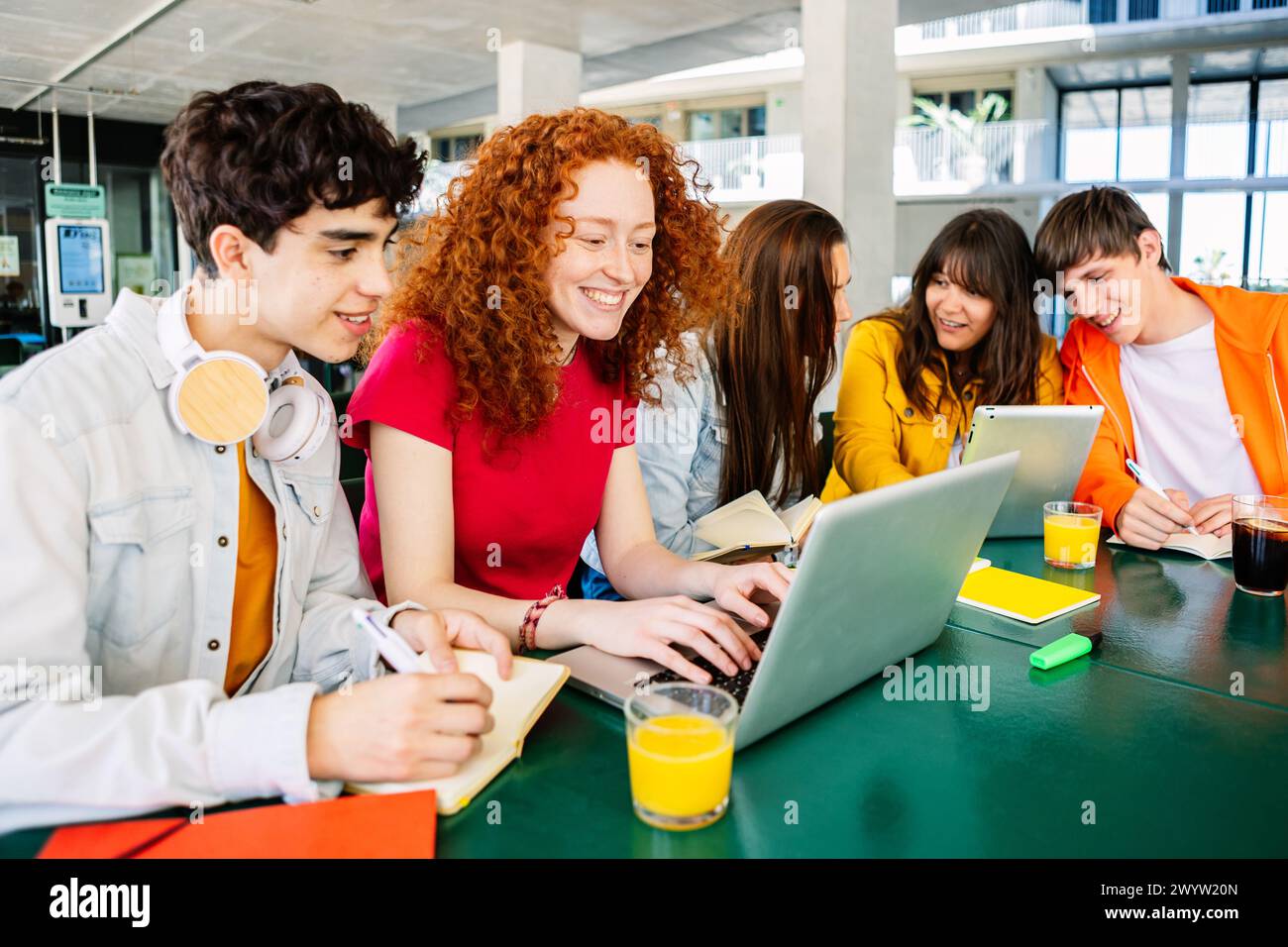 Jeune groupe d'amis étudiants travaillant ensemble sur ordinateur portable sur le campus universitaire Banque D'Images