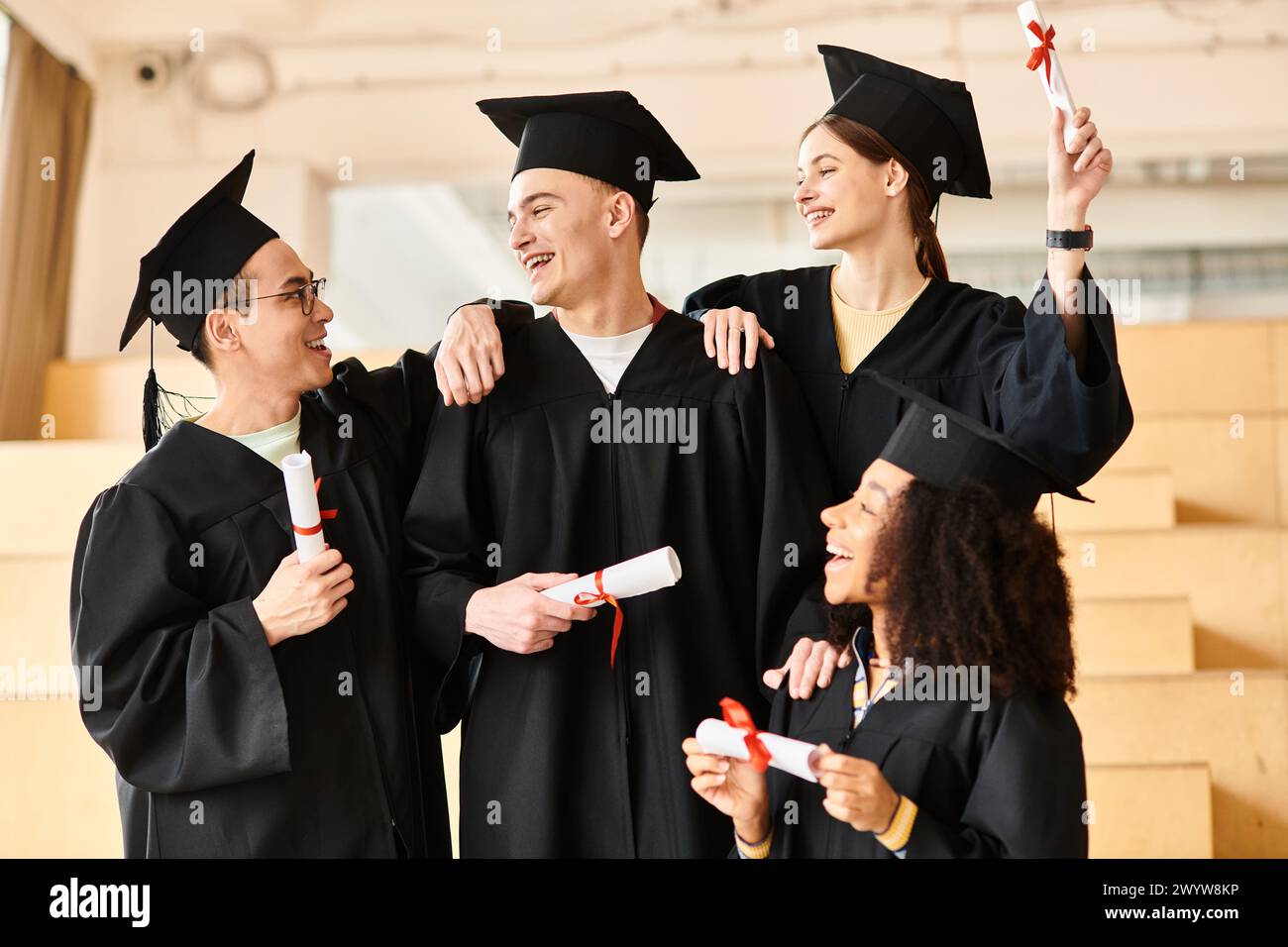 Un groupe diversifié d'étudiants, y compris des individus caucasiens, asiatiques et afro-américains, posent joyeusement dans des robes de graduation. Banque D'Images