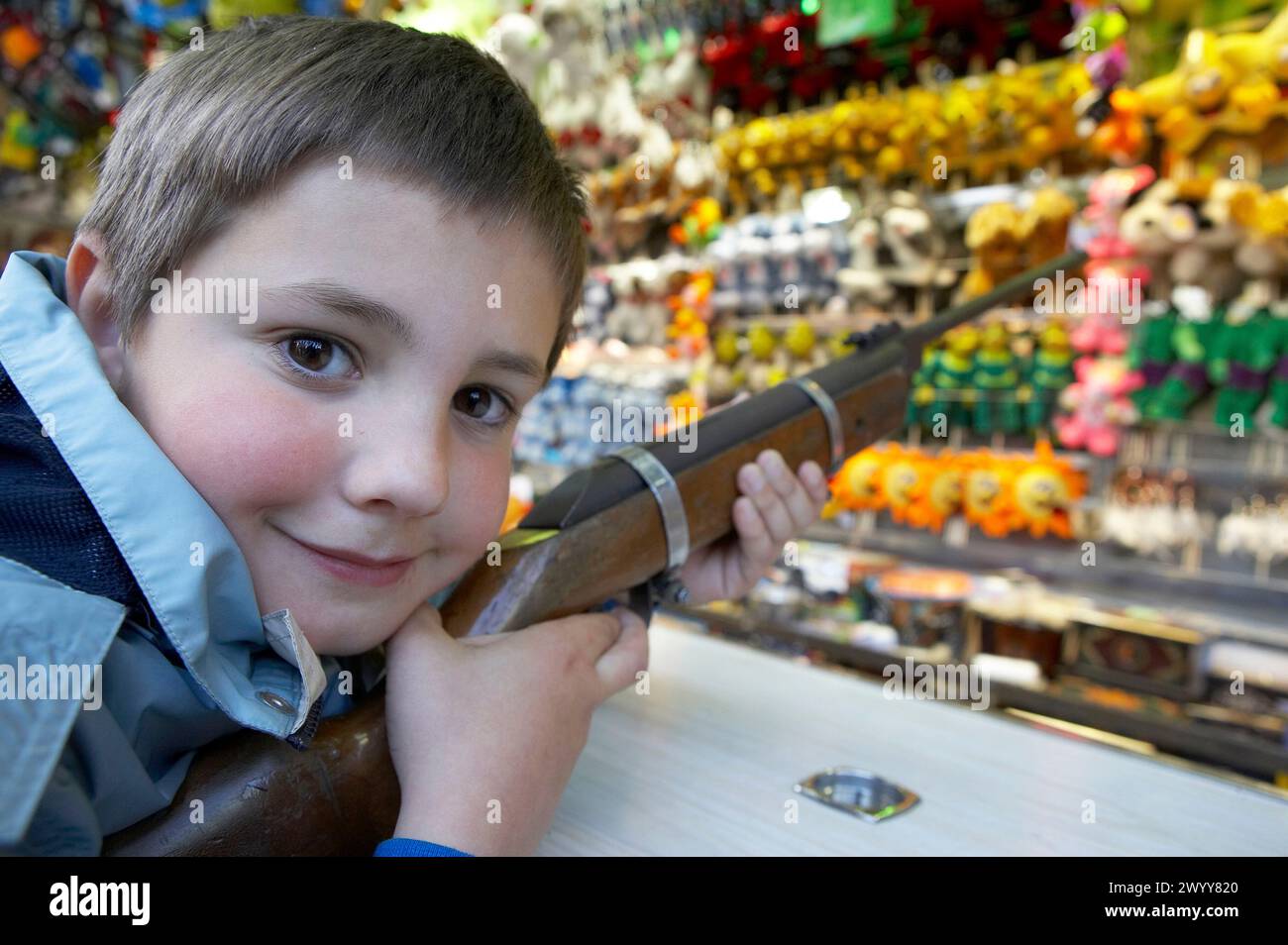 Jeune garçon tirant avec un pistolet à granulés à Funfair. Banque D'Images