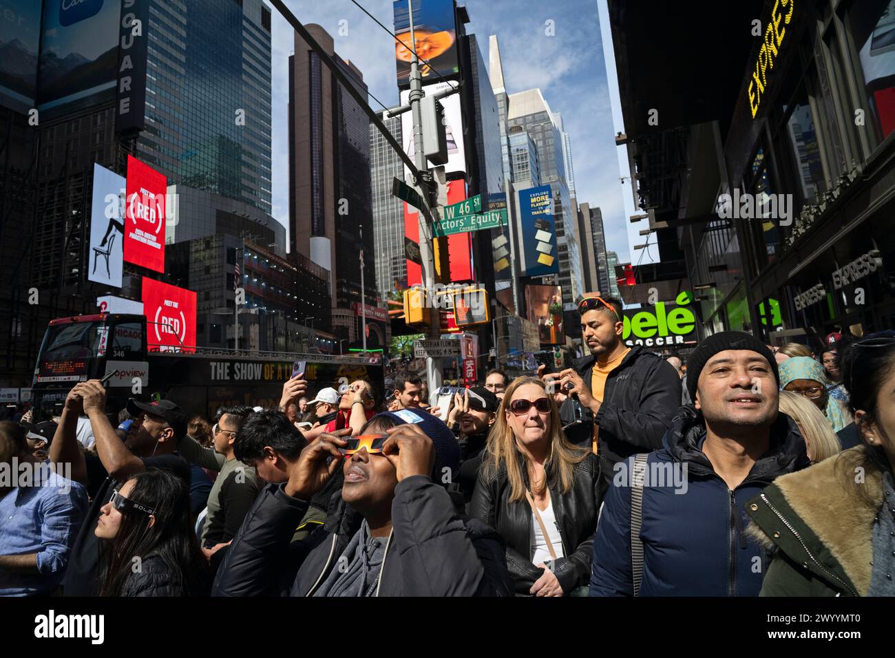 New York, New York, États-Unis 8 avril 2024 les personnes à Times Square regardent la lune passer devant le soleil pendant l'éclipse qui a produit environ 90% de la totalité dans la région de New York Banque D'Images