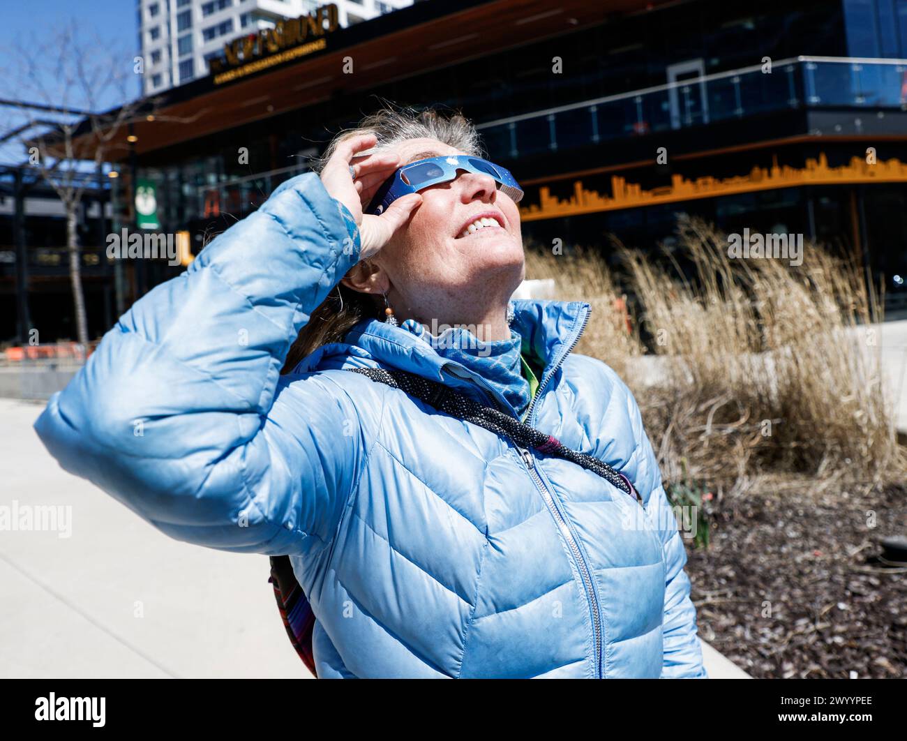 Milwaukee, États-Unis. 08 avril 2024. Mary Beth Checkai regarde à travers des lunettes solaires spéciales la lune se déplace sur le soleil pendant l'éclipse solaire de 2024 à Milwaukee, Wisconsin, le lundi 8 avril 2024. La dernière éclipse en Amérique du Nord remonte à 2017 et la prochaine sera en 2044. Photo de Tannen Maury/UPI crédit : UPI/Alamy Live News Banque D'Images