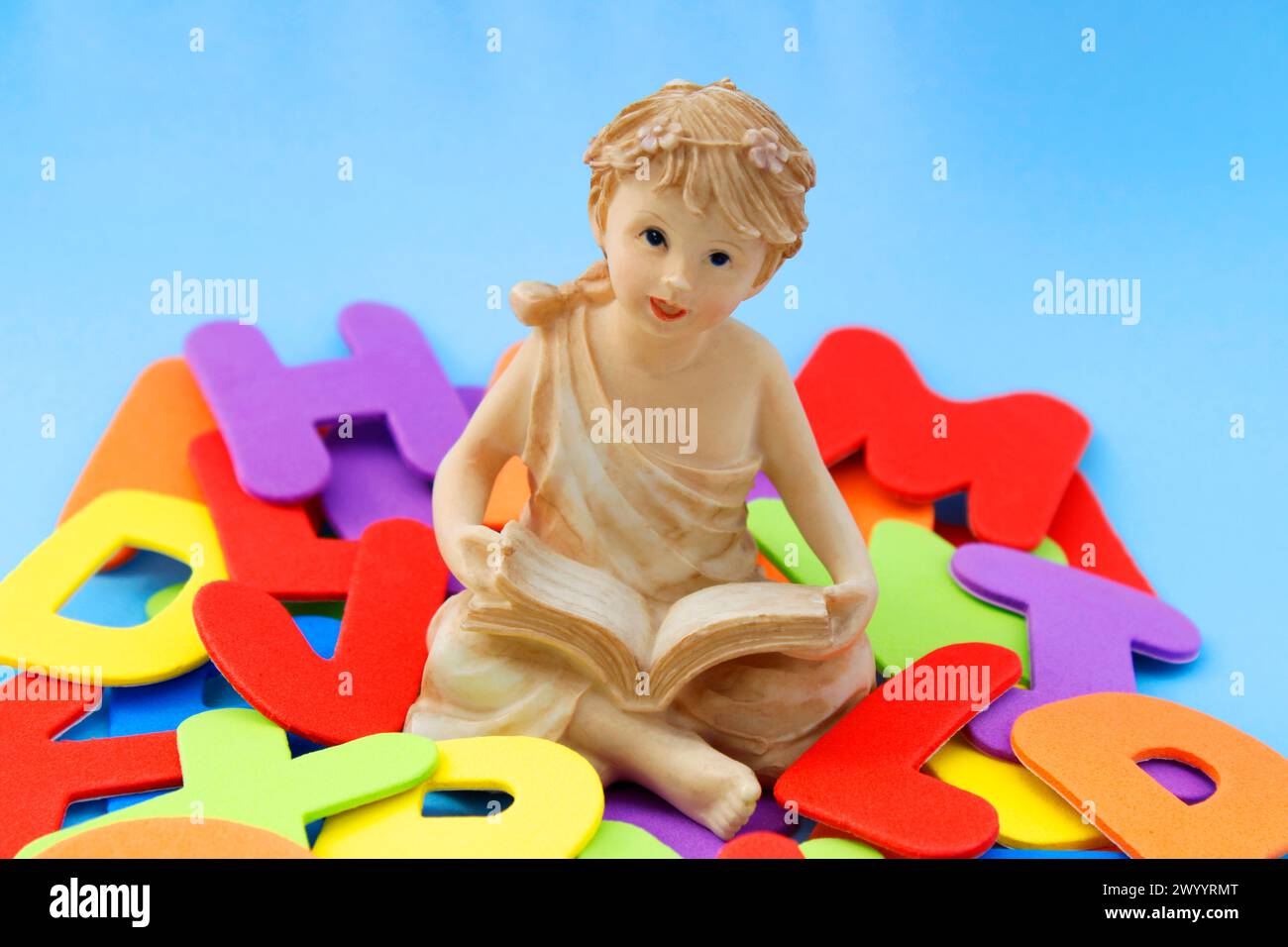 Figure d'une fille avec un livre entouré de lettres colorées Banque D'Images