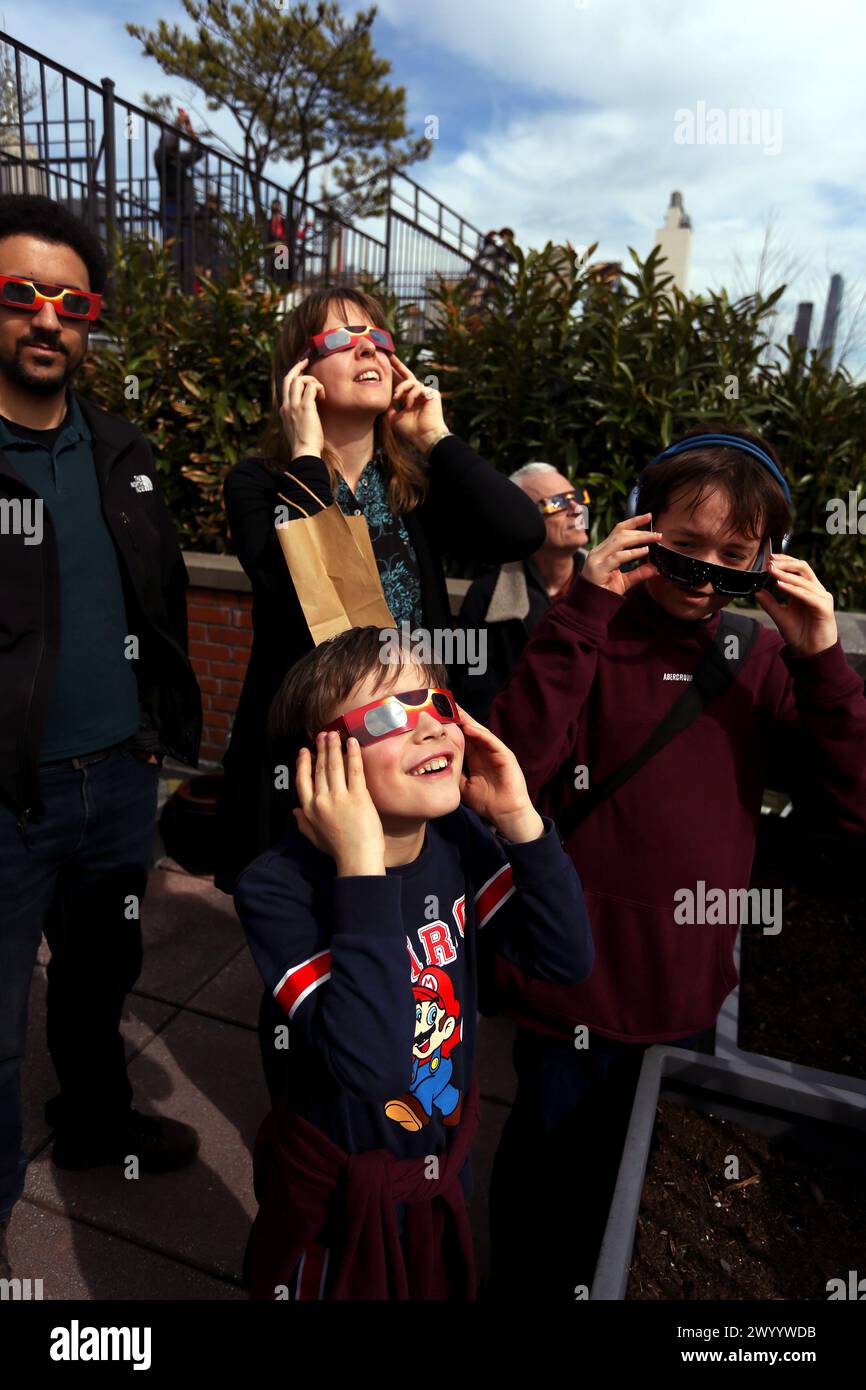 New York City, New York, États-Unis. 08 avril 2024. Les gens se rendent sur un toit dans la section Chelsea de Manhattan à New York pour voir l'éclipse solaire qui était visible au-dessus de l'Amérique du Nord et du Canada aujourd'hui. Crédit : Adam Stoltman/Alamy Live News Banque D'Images