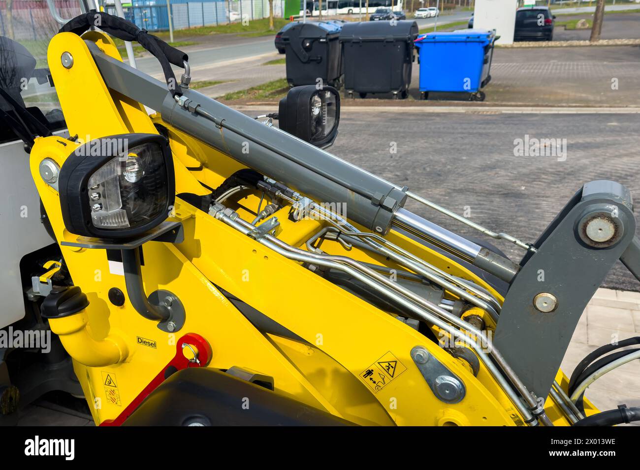 La partie hydraulique jaune d'un tracteur flambant neuf debout sur le bord de la route. Banque D'Images