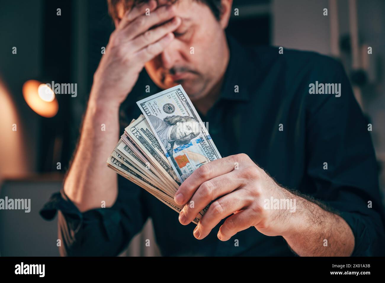Salaire minimum et concept de salaire le plus bas, homme détenant des billets de banque en dollars américains, focus sélectif Banque D'Images