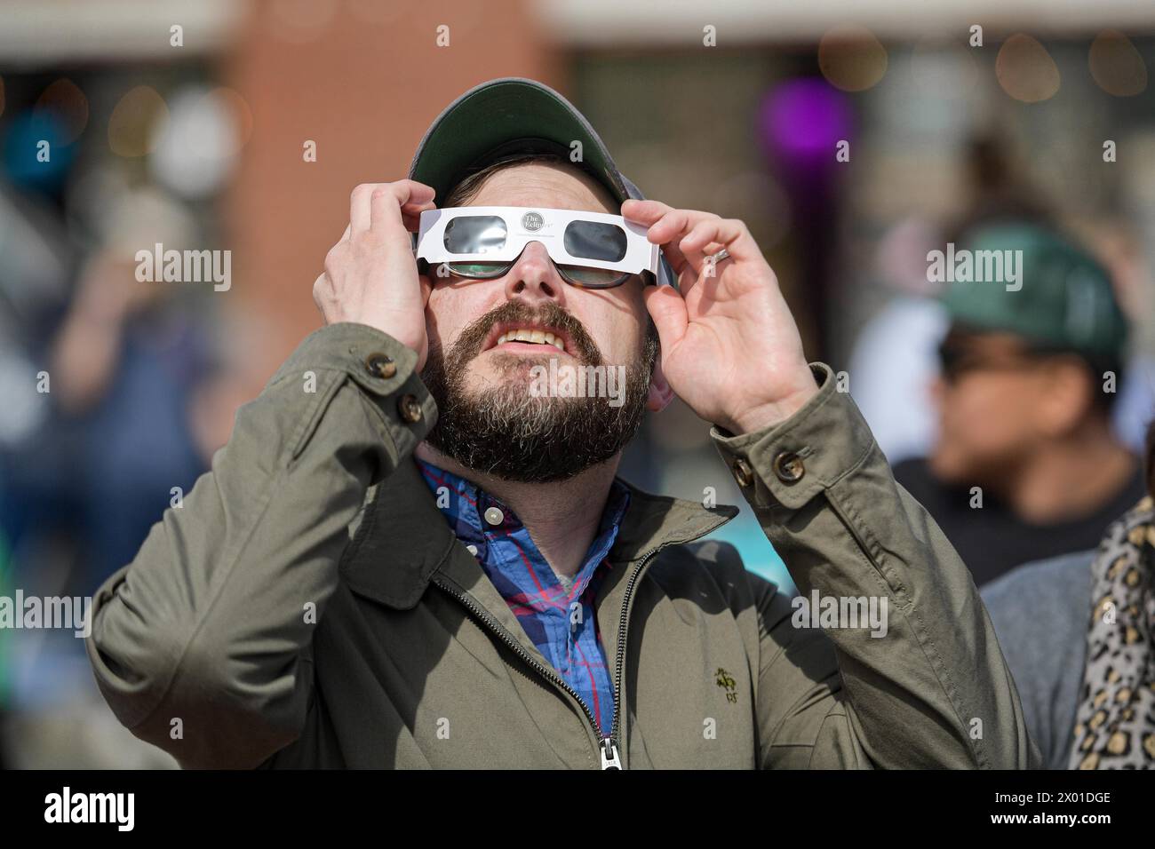 Boston, États-Unis. 8 avril 2024. Un homme regarde une éclipse solaire à Boston, États-Unis, le 8 avril 2024. Une éclipse solaire totale balayait l'Amérique du Nord lundi, alors que les résidents et les visiteurs se rassemblaient à différents endroits sur le chemin de l'éclipse pour regarder et encourager. L'éclipse solaire totale -- surnommée la Grande éclipse américaine pour son long chemin au-dessus de l'Amérique du Nord -- était visible dans le ciel au-dessus de certaines parties du Mexique, de 15 états américains et de l'est du Canada. Crédit : Ziyu Julian Zhu/Xinhua/Alamy Live News Banque D'Images