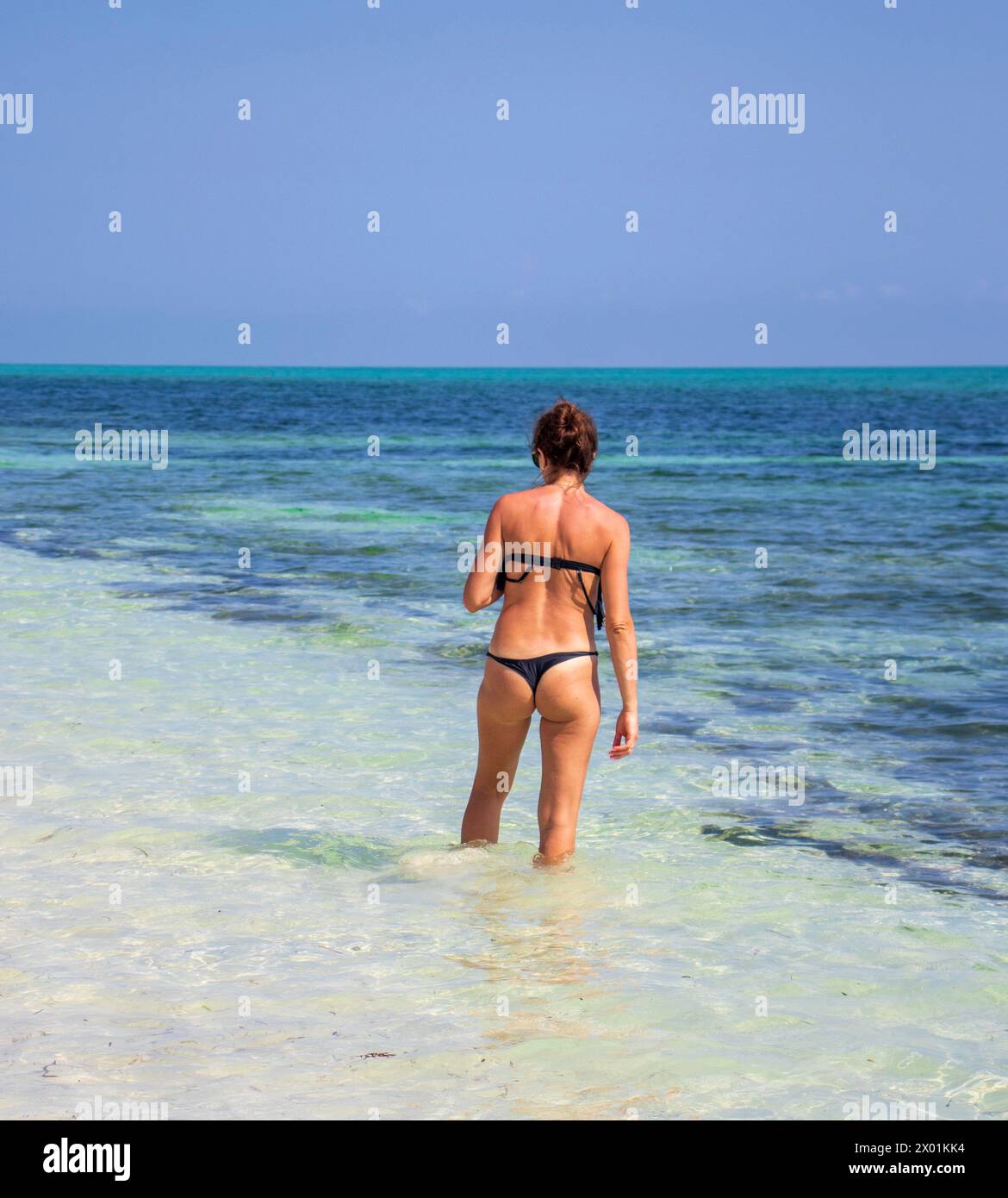 Belle femme dans la suite de natation bikini marchant dans la plage Banque D'Images