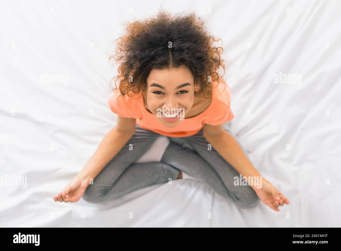 Femme afro-américaine méditant sur le lit, vue de dessus Banque D'Images