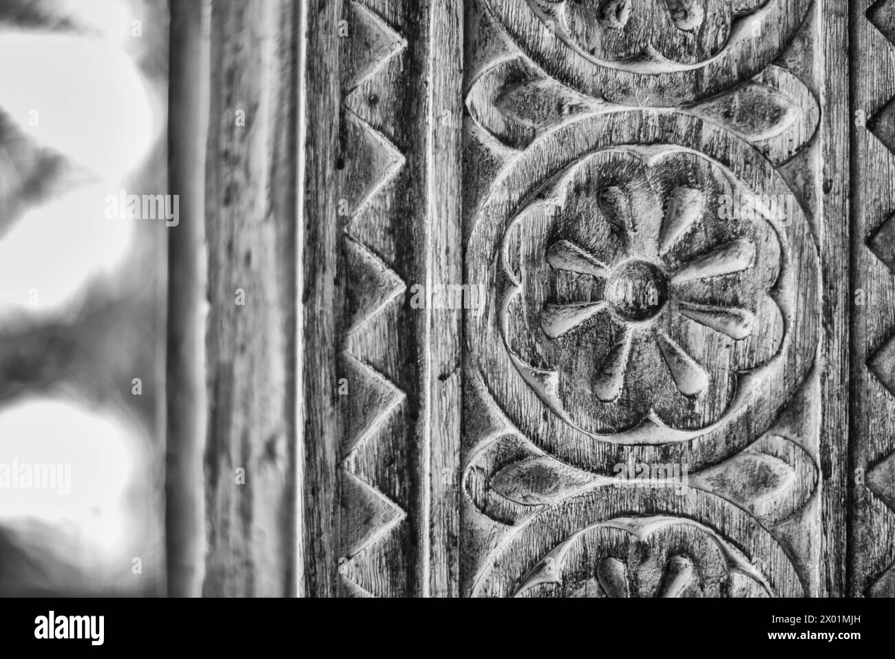Détail filtré monochrome d'un montant de porte en bois sculpté d'une maison arabe traditionnelle restaurée. Banque D'Images