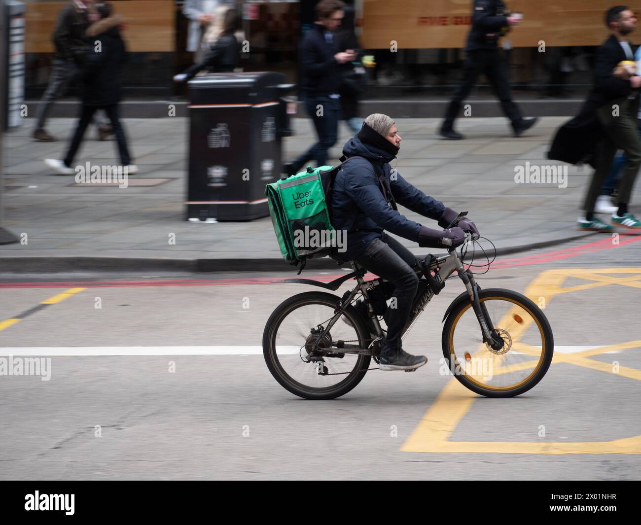 Uber Eats Food Delivery cycliste, dans le centre de Londres, dormant sur le banc Liverpool Street Banque D'Images
