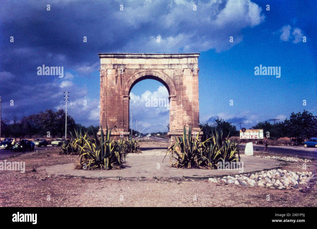 Arc de Berà, un ancien arc de triomphe près de Roda de Bera sur la route N-340 vers Sitges, Espagne, en août 1965. Le panneau indique Sitges 37kM. L'Arc de Berà a été construit à cheval sur la via Augusta à la fin du Ier siècle av. J.-C. Banque D'Images