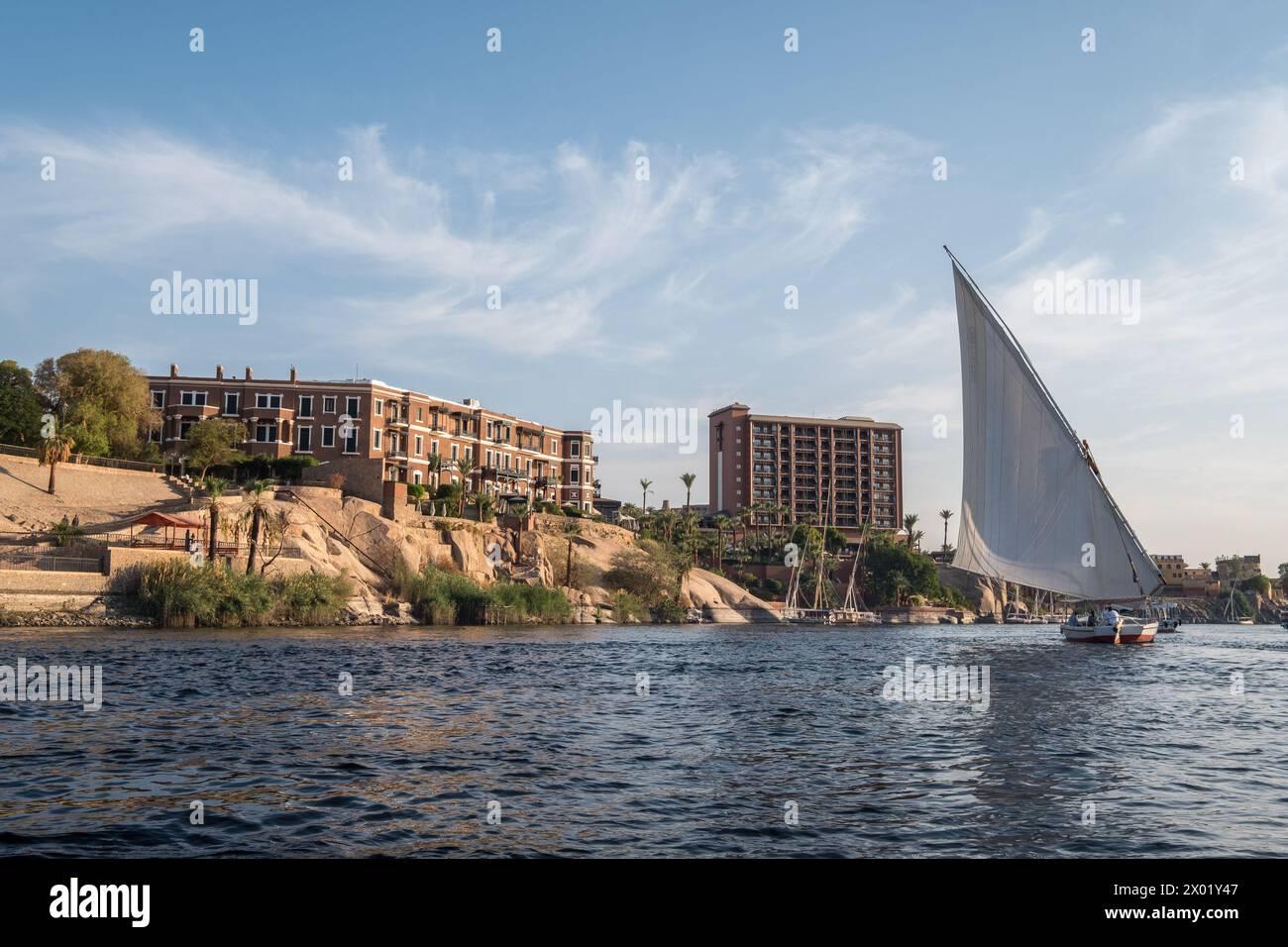 ASSOUAN, EGYPTE - 03 SEPTEMBRE 2017 : felouque égyptienne ou voilier sur le Nil à Assouan avec le célèbre Old Cataract Hotel sur le rivage. Banque D'Images