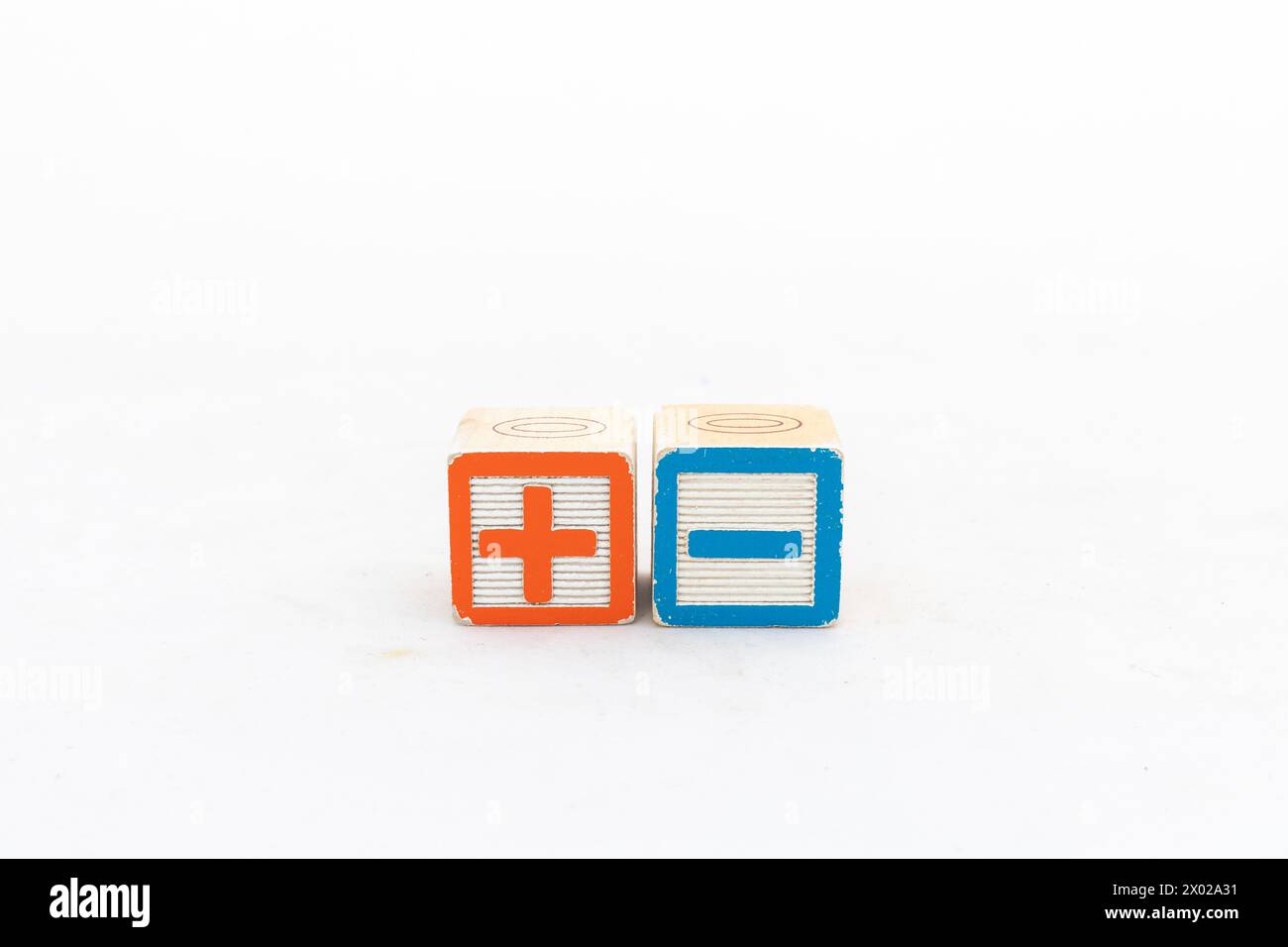 Blocs de bois montrant des signes plus et moins isolés sur fond blanc Banque D'Images