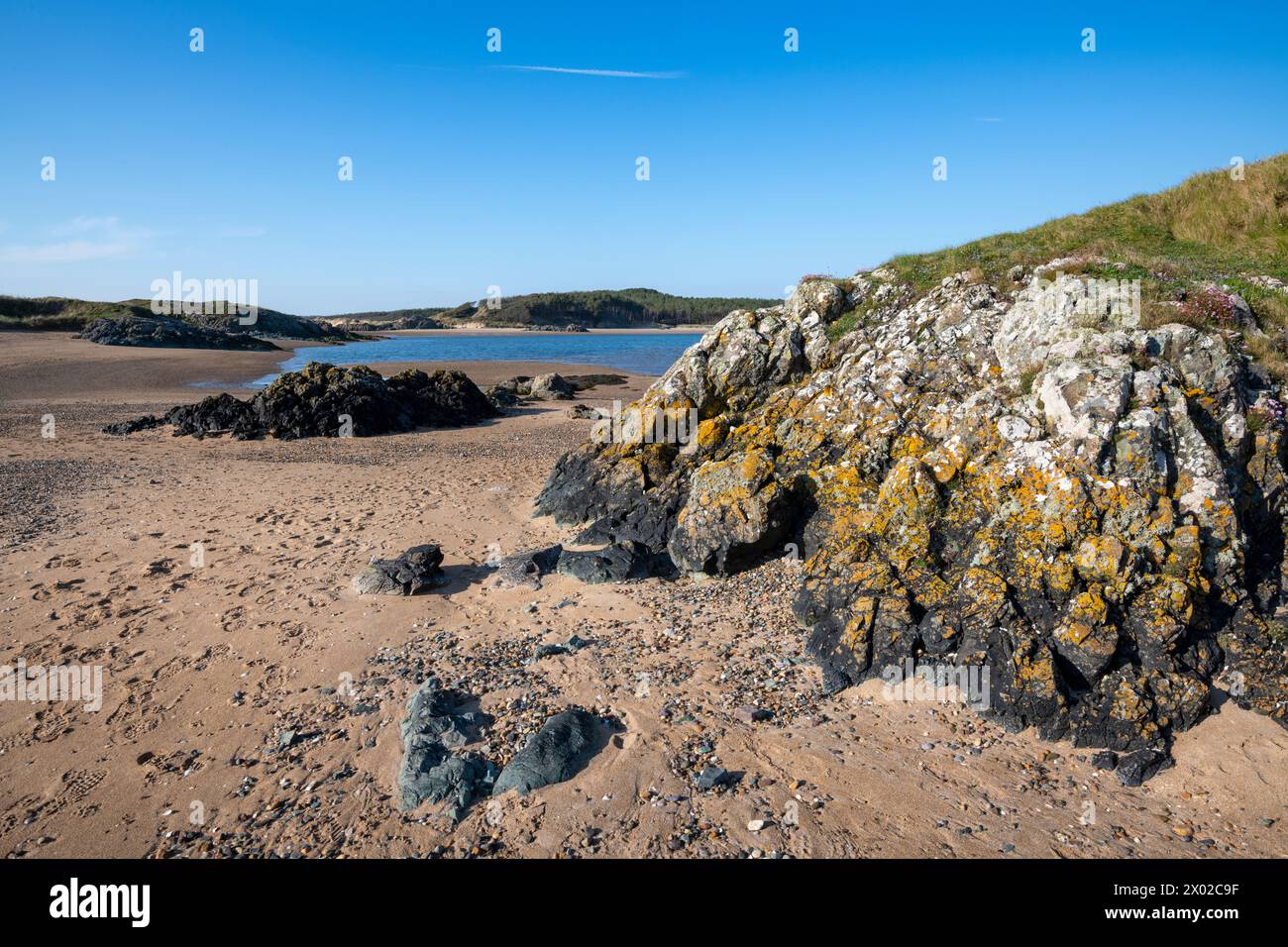 Rochers entre Llanddwyn Island et Newborough Beach, Anglesey, pays de Galles du Nord. Banque D'Images