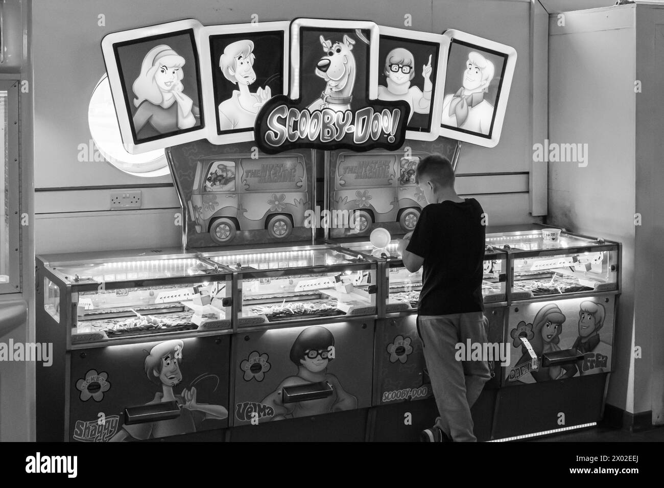 Jeux d'arcade et joueur sur Teignmouth Pier, Devon, Royaume-Uni. Photographie noir et blanc. Banque D'Images