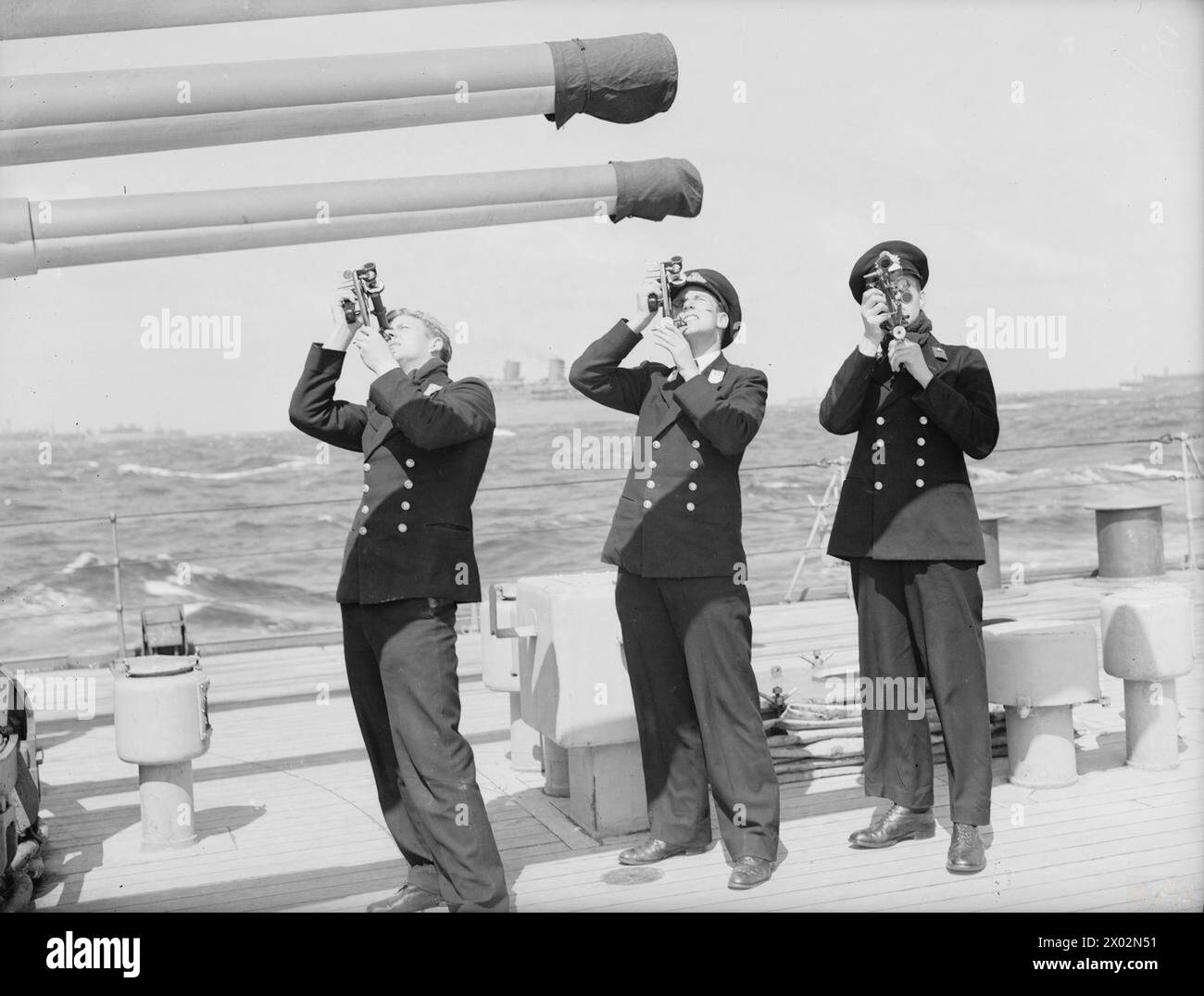 Trois aspirants pratiquent le tir au soleil pour une formation à la navigation à bord du HMS Mauritius en mer le 12 mai 1942, développant des compétences en navigation céleste. Banque D'Images