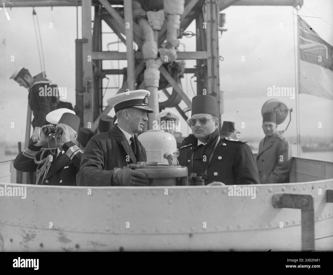 LE ROI FAROUK VISITE LE PORTE-AVIONS D'ESCORTE BRITANNIQUE. MARS 1945, À BORD DU HMS HUNTER, ALEXANDRIE, ÉGYPTE. - Le roi Farouk discute avec le vice-amiral Tennant sur le pont du CHASSEUR Banque D'Images