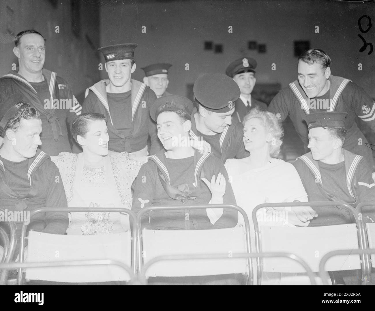 Mlle Evelyn Laye et Mlle Beatrice Lillie sont assises parmi les marins lors de l'ouverture de la nouvelle Royal Navy et Royal Marine Canteen en 1941 à Rosyth, avec animation. Banque D'Images