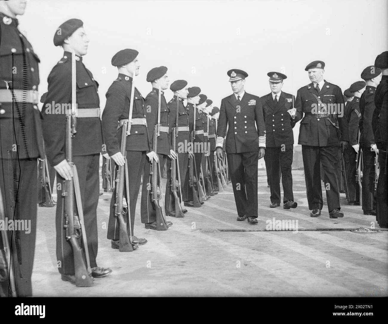 SA MAJESTÉ LE ROI À PORTSMOUTH. 16 NOVEMBRE 1944, LORS DE LA VISITE DU ROI À LA BASE ET À DIVERS NAVIRES. - Le roi à bord du porte-avions HMS INDEFATIGABLE inspecte les Royal Marines Banque D'Images