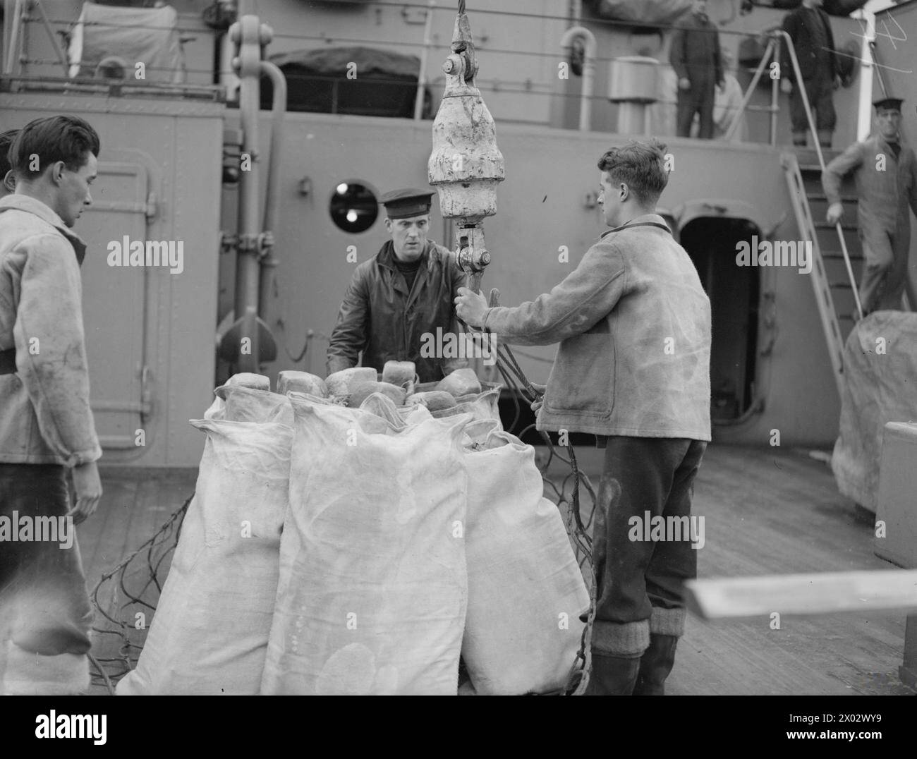 LA ROUTINE QUOTIDIENNE DU HMS TYNE, UN NAVIRE DE DÉPÔT DESTROYER. MOUILLAGE DE LA FLOTTE, 17 OCTOBRE 1942. - Une charge de pain pour un destroyer étant hissé sur la grue prête à être descendue dans un drifter en attente Banque D'Images