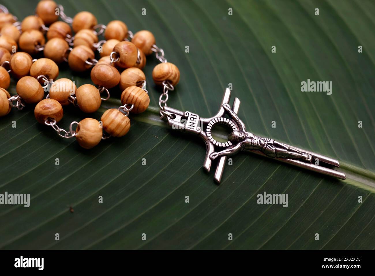 Rosaire (perles de prière) sur une feuille verte, et Jésus sur la Croix (crucifix), Cambodge, Indochine, Asie du Sud-est, Asie Banque D'Images